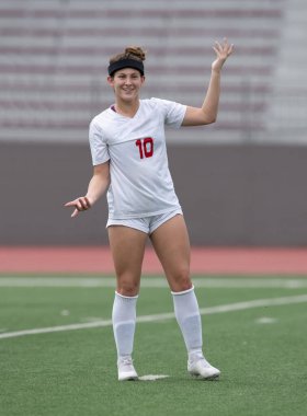 Genç çekici atletik kız bir oyunda futbol oynuyor.