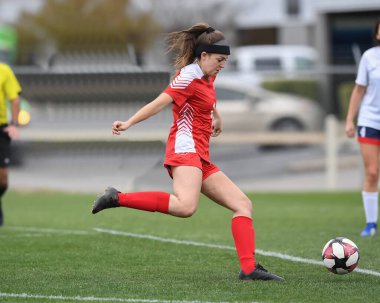 Genç çekici atletik kız bir oyunda futbol oynuyor.