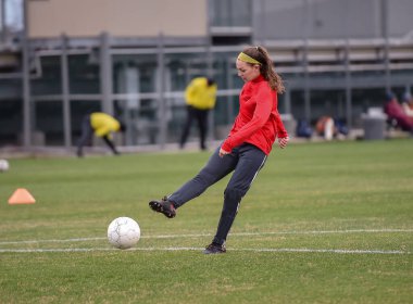 Genç çekici atletik kız bir oyunda futbol oynuyor.