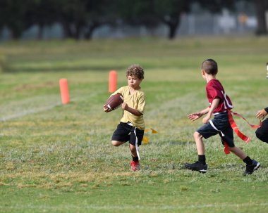 Bayrak futbolu oynayan genç çocuk.
