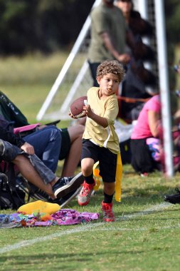 Bayrak futbolu oynayan genç çocuk.