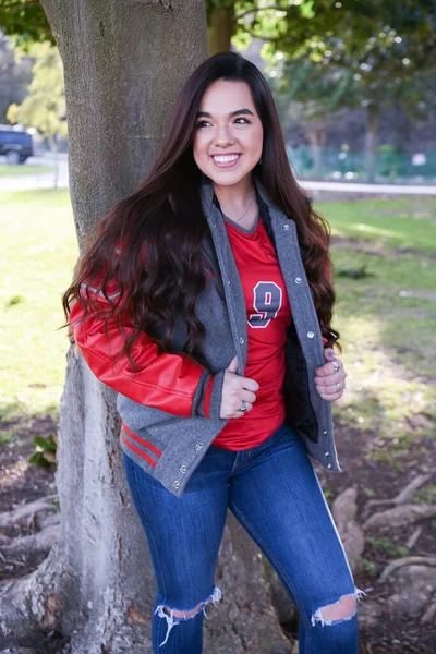 Young Female High School Senior posing for Senior photos in a beautiful park setting