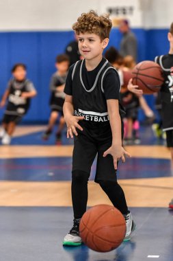 Genç sporcu çocuk maç sırasında harika basketbol oynuyor.