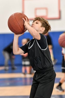 Genç sporcu çocuk maç sırasında harika basketbol oynuyor.