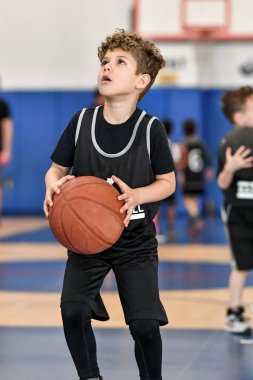 Genç sporcu çocuk maç sırasında harika basketbol oynuyor.