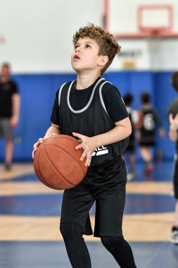 Genç sporcu çocuk maç sırasında harika basketbol oynuyor.