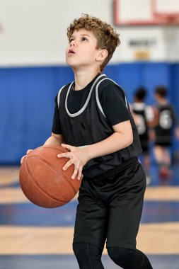 Genç sporcu çocuk maç sırasında harika basketbol oynuyor.