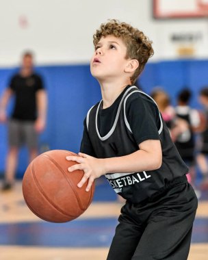 Genç sporcu çocuk maç sırasında harika basketbol oynuyor.