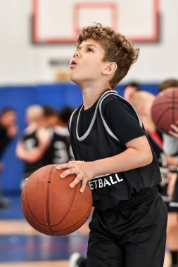 Genç sporcu çocuk maç sırasında harika basketbol oynuyor.