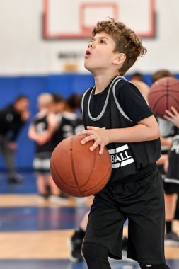 Genç sporcu çocuk maç sırasında harika basketbol oynuyor.