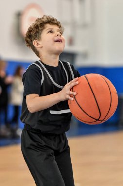 Genç sporcu çocuk maç sırasında harika basketbol oynuyor.