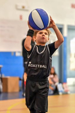 Genç sporcu çocuk maç sırasında harika basketbol oynuyor.