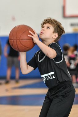 Genç sporcu çocuk maç sırasında harika basketbol oynuyor.