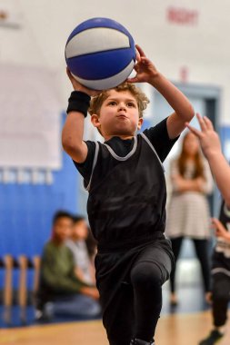 Genç sporcu çocuk maç sırasında harika basketbol oynuyor.