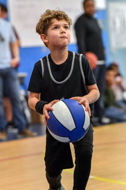 Genç sporcu çocuk maç sırasında harika basketbol oynuyor.