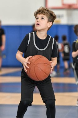 Genç sporcu çocuk maç sırasında harika basketbol oynuyor.