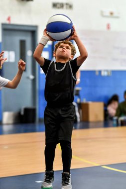 Genç sporcu çocuk maç sırasında harika basketbol oynuyor.