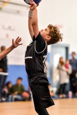 Genç sporcu çocuk maç sırasında harika basketbol oynuyor.