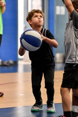 Genç sporcu çocuk maç sırasında harika basketbol oynuyor.