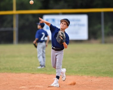 Yakışıklı genç beysbol oyuncusunun bir beyzbol maçı sırasında inanılmaz oyunlar oynadığı aksiyon fotoğrafı.