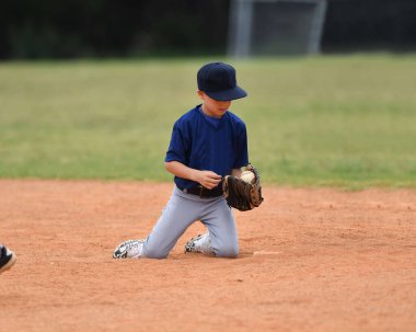 Yakışıklı genç beysbol oyuncusunun bir beyzbol maçı sırasında inanılmaz oyunlar oynadığı aksiyon fotoğrafı.