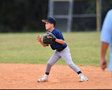 Yakışıklı genç beysbol oyuncusunun bir beyzbol maçı sırasında inanılmaz oyunlar oynadığı aksiyon fotoğrafı.