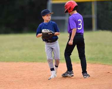 Action photo of handsome young baseball player making amazing plays during a baseball game clipart