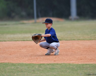 Yakışıklı genç beysbol oyuncusunun bir beyzbol maçı sırasında inanılmaz oyunlar oynadığı aksiyon fotoğrafı.