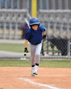 Yakışıklı genç beysbol oyuncusunun bir beyzbol maçı sırasında inanılmaz oyunlar oynadığı aksiyon fotoğrafı.