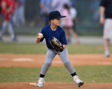 Yakışıklı genç beysbol oyuncusunun bir beyzbol maçı sırasında inanılmaz oyunlar oynadığı aksiyon fotoğrafı.
