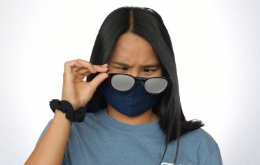 Koruyucu maske taktığı için sisli gözlüklü tatlı Asyalı kız.