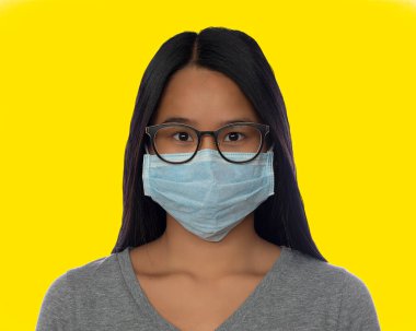 Koruyucu maske taktığı için sisli gözlüklü tatlı Asyalı kız.