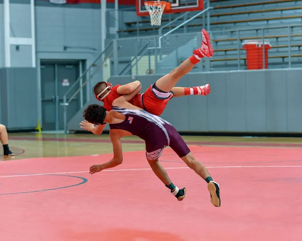 Athletic male wrestlers competing at a wrestling meet.