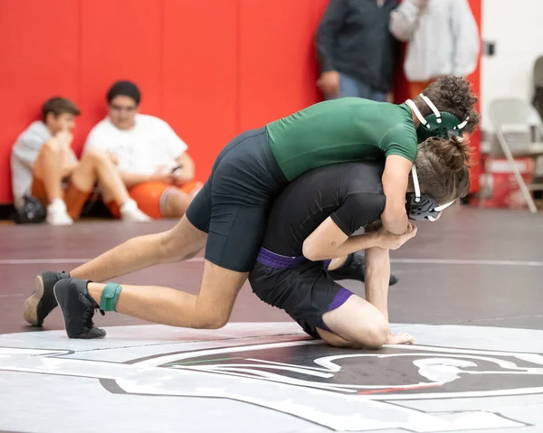 Athletic male wrestlers competing at a wrestling meet.