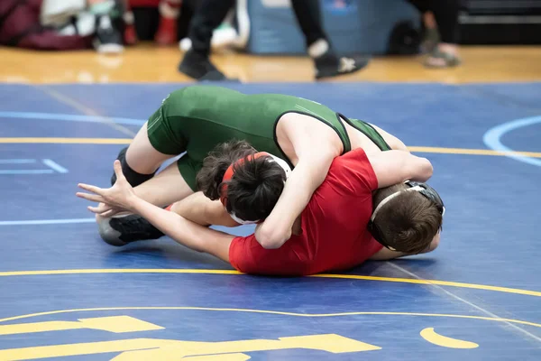 Athletic male wrestlers competing at a wrestling meet.