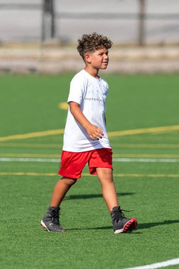 Bayrak futbolunda oynayan tatlı bir çocuk.