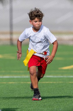 Bayrak futbolunda oynayan tatlı bir çocuk.