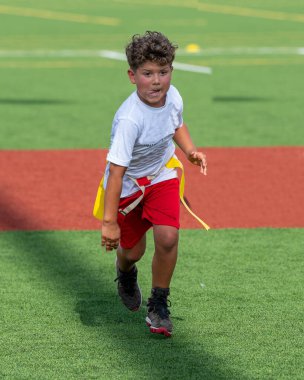 Bayrak futbolunda oynayan tatlı bir çocuk.