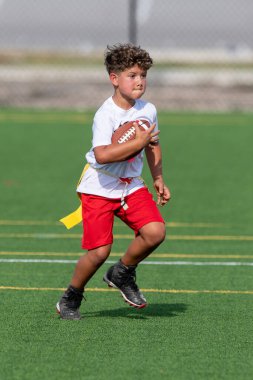 Bayrak futbolunda oynayan tatlı bir çocuk.