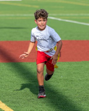 Bayrak futbolunda oynayan tatlı bir çocuk.