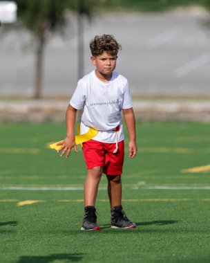 Bayrak futbolunda oynayan tatlı bir çocuk.