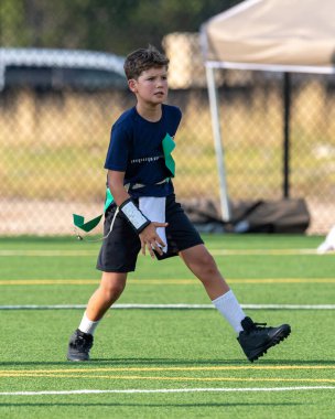 Genç atletik çocuk bayrak futbolunda oynuyor.
