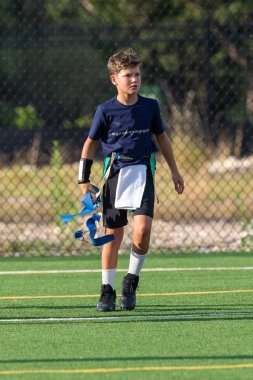 Genç atletik çocuk bayrak futbolunda oynuyor.