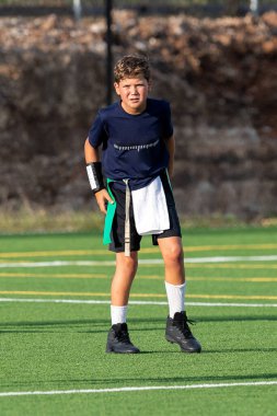 Genç atletik çocuk bayrak futbolunda oynuyor.