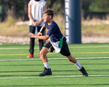 Genç atletik çocuk bayrak futbolunda oynuyor.