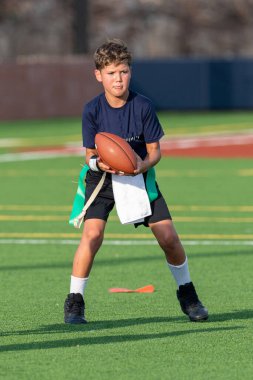 Genç atletik çocuk bayrak futbolunda oynuyor.