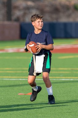 Genç atletik çocuk bayrak futbolunda oynuyor.