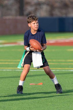 Genç atletik çocuk bayrak futbolunda oynuyor.