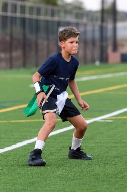 Genç atletik çocuk bayrak futbolunda oynuyor.