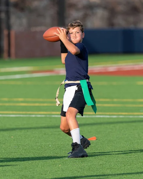 Genç atletik çocuk bayrak futbolunda oynuyor.